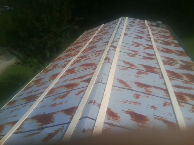 Rusted metal roof panels with new wood purlins before replacement — Storm Damage Roof Repair in London by Roofing Brothers